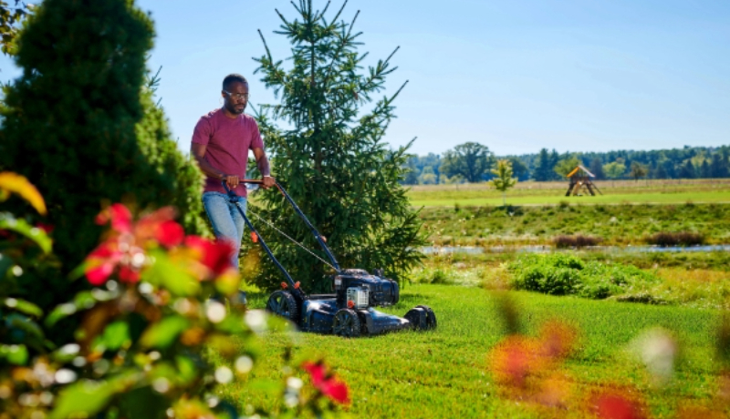 Man pushing a Briggs & Stratton powered push mower.